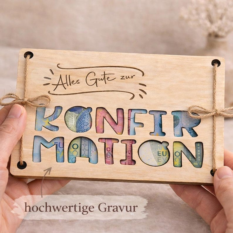 May include: A wooden gift card with the word "KONFIRMATION" cut out, revealing colorful money. The card has the text "Alles Gute zur" engraved at the top and is tied with twine. The phrase "hochwertige Gravur" is also visible.