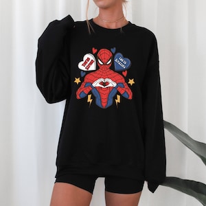 May include: Black sweatshirt with a graphic of Spiderman making a heart shape with his hands. The graphic includes three hearts with the text "You're Amazing", "Be My Boo", and "I Love You" on them.