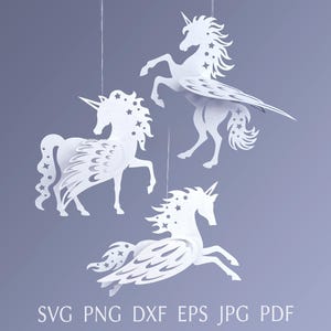 Pode incluir: Três recortes de unicórnios de papel branco suspensos contra um fundo roxo pálido. Cada unicórnio tem um chifre, uma crina fluida e detalhes de estrelas. O texto "SVG PNG DXF EPS JPG PDF" está na parte inferior.