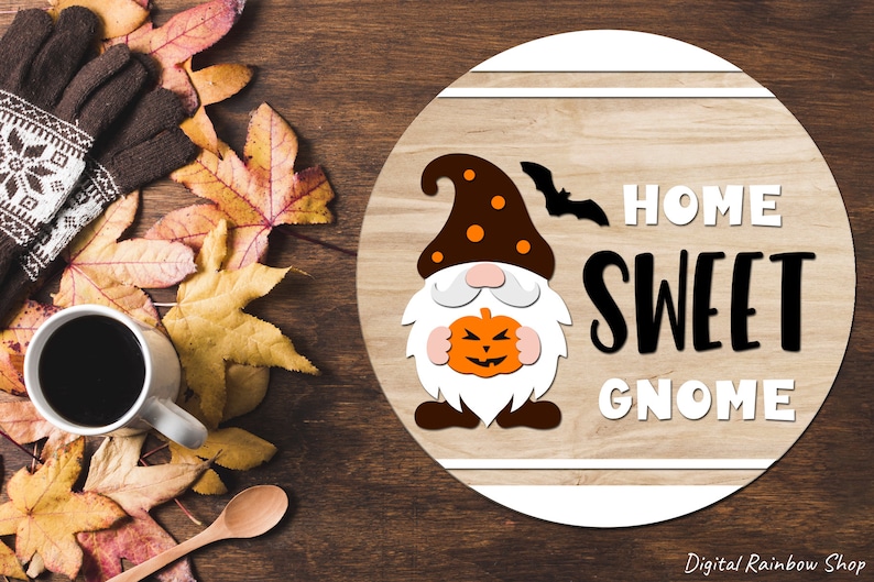 Puede incluir: Un letrero redondo de madera con un borde blanco y un fondo de madera marr&oacute;n. El letrero presenta un gnomo de dibujos animados sosteniendo una calabaza con una cara espeluznante. El texto "Home Sweet Gnome" est&aacute; escrito en letras blancas y negras.