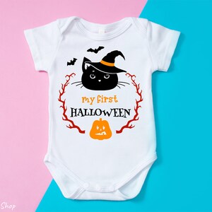 Puede incluir: Un body blanco para beb&eacute; con un gato negro que lleva un sombrero de bruja y una calabaza. El texto "my first HALLOWEEN" est&aacute; impreso en el body.