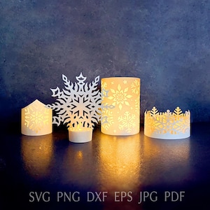 以下が含まれることがあります： 冬をテーマにした、光る切り絵のコレクション。大きな雪の結晶、いくつかのキャンドルホルダー、小さな家型のランタンが含まれています。キャンドルホルダーとランタンには雪の結晶の切り抜きがあります。「SVG PNG DXF EPS JPG PDF」の文字が下にあります。