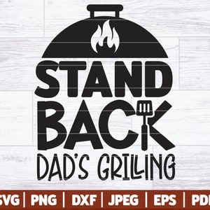 Könnte beinhalten: Schwarzweißes Grafikdesign mit einem Grill, Flammen und dem Text "STAND BACK DAD'S GRILLING".