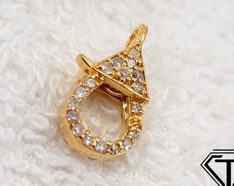 May include: Gold-tone clasp with clear cubic zirconia stones. The clasp is shaped like a triangle with a loop on the bottom.
