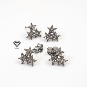 Pu&ograve; includere: Un paio di orecchini a forma di stella argentati con piccoli diamanti. Ogni orecchino presenta tre stelle impilate l'una sull'altra.