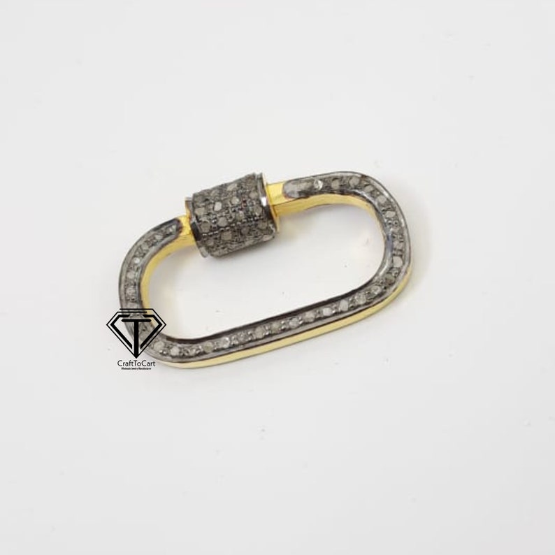 Puede incluir: Un cierre ovalado de plata y oro con un dise&ntilde;o engastado con diamantes. El cierre es un hallazgo de joyer&iacute;a popular utilizado para collares, pulseras y otras piezas de joyer&iacute;a.