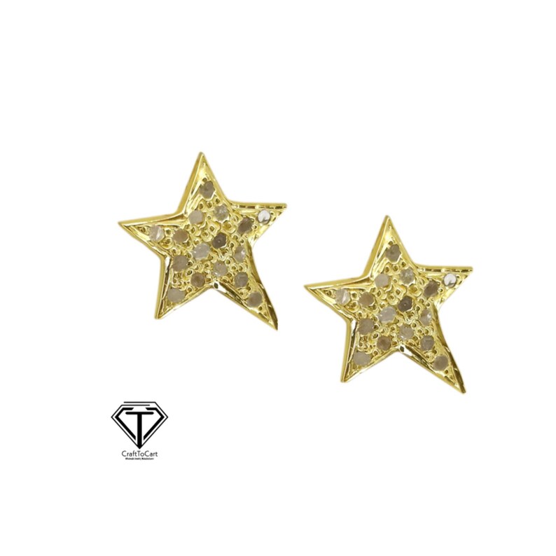May include: A pair of gold star-shaped earrings with small, clear stones set into the surface of the stars.