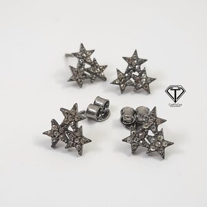 Pu&ograve; includere: Un paio di orecchini a forma di stella argentati con piccole pietre trasparenti. Ogni orecchino presenta tre stelle sovrapposte.