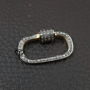 Puede incluir: Un cierre ovalado de plata y oro con un dise&ntilde;o engastado con diamantes. El cierre es un hallazgo de joyer&iacute;a popular para collares, pulseras y otras piezas de joyer&iacute;a.
