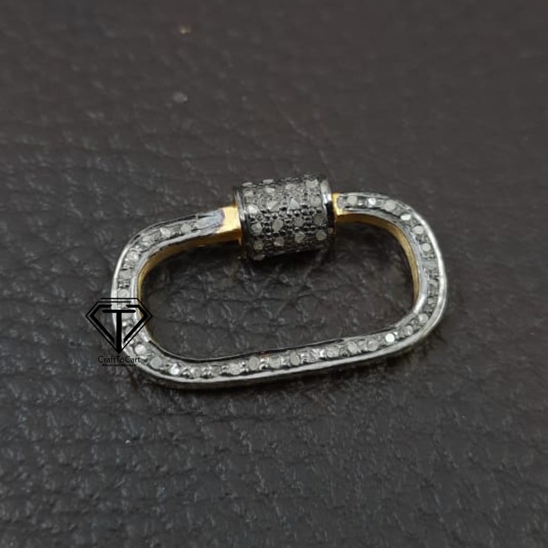 Puede incluir: Un cierre ovalado de plata y oro con un dise&ntilde;o engastado con diamantes. El cierre es un hallazgo de joyer&iacute;a popular para collares, pulseras y otras piezas de joyer&iacute;a.