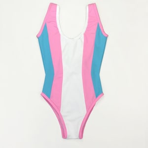 May include: A white swimsuit with pink and blue vertical stripes. The swimsuit has a scoop neck and a low back.