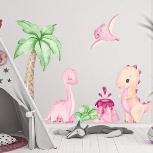 Puede incluir: Calcoman&iacute;as de pared de dinosaurios rosas y verdes con una palmera, un volc&aacute;n y un dinosaurio volador. Las calcoman&iacute;as son perfectas para la habitaci&oacute;n de un ni&ntilde;o.