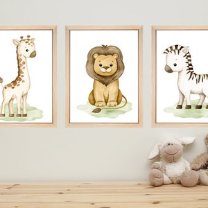 May include: Three framed watercolor illustrations of safari animals. The first frame shows a giraffe with brown spots, the second frame shows a lion with a brown mane, and the third frame shows a zebra with black and white stripes.
