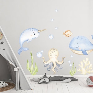 Puede incluir: Un conjunto de calcoman&iacute;as de pared de animales de acuarela azul y beige que incluyen una narval, una ballena, un pulpo y un coral. Las calcoman&iacute;as son perfectas para una guarder&iacute;a o una habitaci&oacute;n infantil.