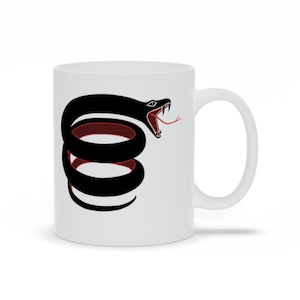 May include: White ceramic coffee mug featuring a black and red coiled snake design. The snake has a red tongue and is in a striking pose.
