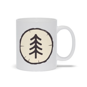 Peut inclure: Une tasse en céramique blanche avec une illustration en noir et blanc d'une tranche d'arbre avec un arbre stylisé au centre.