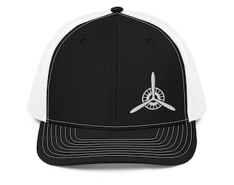 May include: Black and white trucker hat with a white propeller logo embroidered on the front.