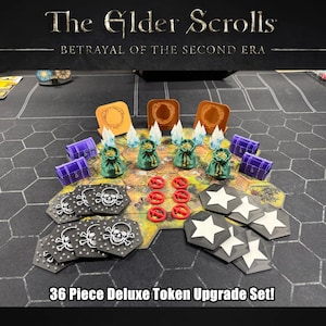 Puede incluir: Un set de 36 fichas de lujo para el juego de mesa The Elder Scrolls: Betrayal of the Second Era. El conjunto incluye cofres del tesoro morados, bolsas de dinero verdes, fragmentos de cristal azules, fichas de calavera negras, rojas y estrellas.
