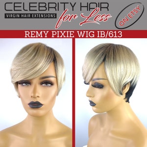 Op de afbeelding: Een blonde pixie pruik met zwarte wortels op een mannequinhoofd. De pruik is gestyled met een scheiding aan de zijkant en een pony. De pruik is gelabeld "REMY PIXIE WIG IB/613".