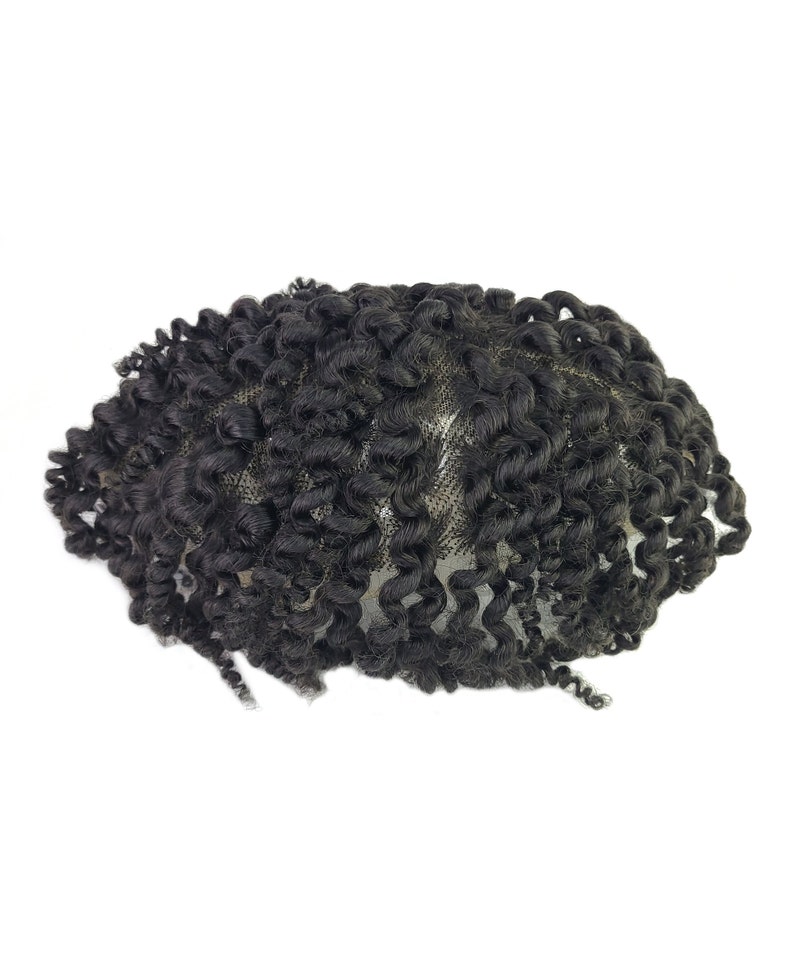 Pu&ograve; includere: Un'extension per capelli ricci neri, probabilmente una parrucca o un'estensione per capelli, su sfondo bianco. I capelli sono fittamente arricciati, con un aspetto naturale. L'extension &egrave; progettata per essere indossata sulla testa.