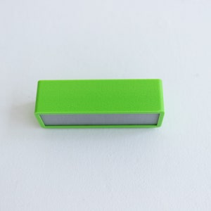 May include: A small, rectangular, green speaker with a gray front panel.