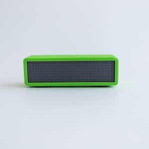 May include: A small, rectangular, green speaker with a black display screen.