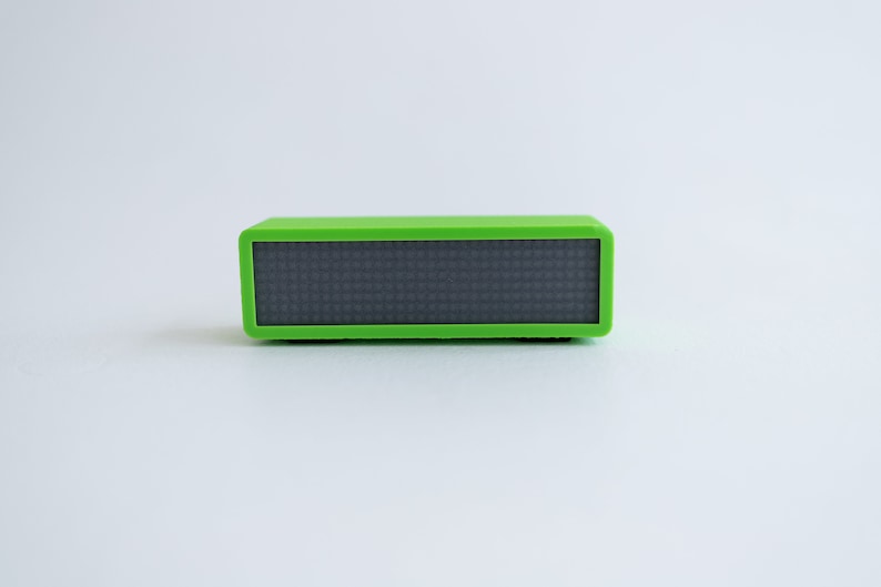 May include: A small, rectangular, green speaker with a black display screen.