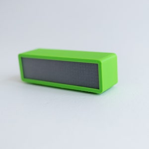 May include: A small, bright green portable speaker with a black speaker grille.