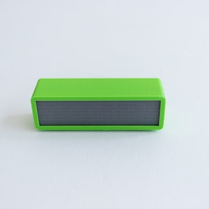 May include: A small, bright green rectangular speaker with a black speaker grille.