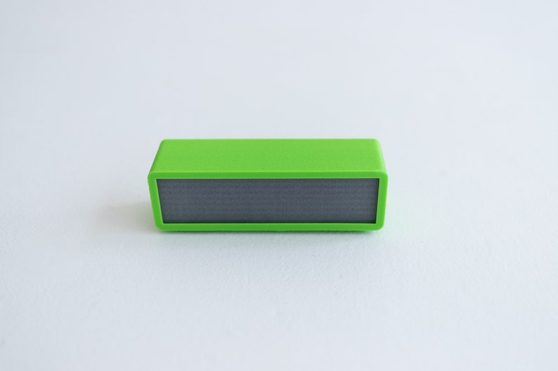 May include: A small, bright green rectangular speaker with a black speaker grille.
