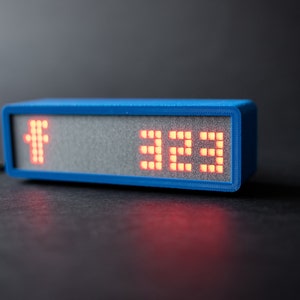 May include: A blue rectangular device with a red LED display showing the number "322".