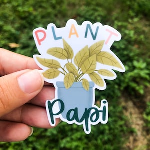 May include: A white sticker with a green plant in a blue pot. The text "Plant Papi" is written in green below the plant. The word "Plant" is written in colorful letters above the plant.