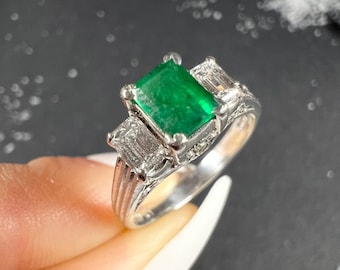 Bague trois pierres en platine, émeraude et diamant des années 40 sur un anneau décoratif