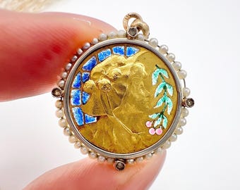 May include: A gold pendant with a blue and green enamel design. The pendant is surrounded by a row of white pearls and small diamonds.