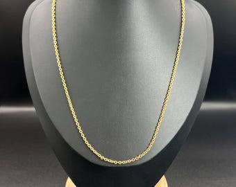 May include: A gold chain necklace on a black display stand. The chain is a simple, delicate design.