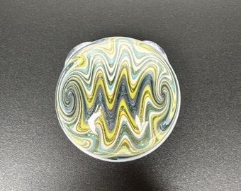 May include: A glass bowl with a swirling pattern of yellow, green, and blue. The bowl has a clear, glossy finish.