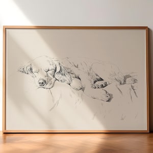 以下が含まれることがあります： 枕の上で眠る犬の白黒の線画。犬は丸まって、頭を足の上に置いています。絵は明るい木製の額縁に入っています。