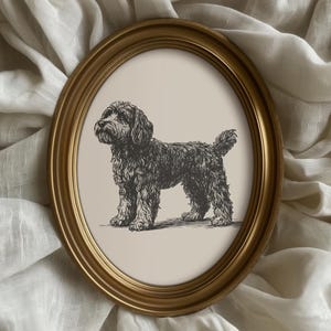 May include: Oval gold-framed print featuring a detailed black and white illustration of a dog. The dog has a fluffy coat and stands on a neutral background. The frame adds a classic touch to the artwork, suitable for home decor.