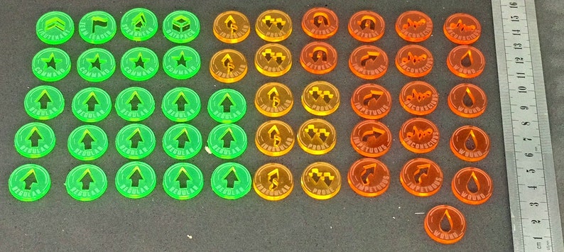 May include: A set of 40 plastic game tokens in green, orange, and red. The tokens feature various symbols, including arrows, stars, and other abstract shapes.