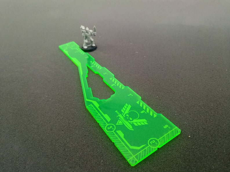 May include: A green plastic ruler with a skull and wings design. The ruler is marked with inches from 3 to 12.