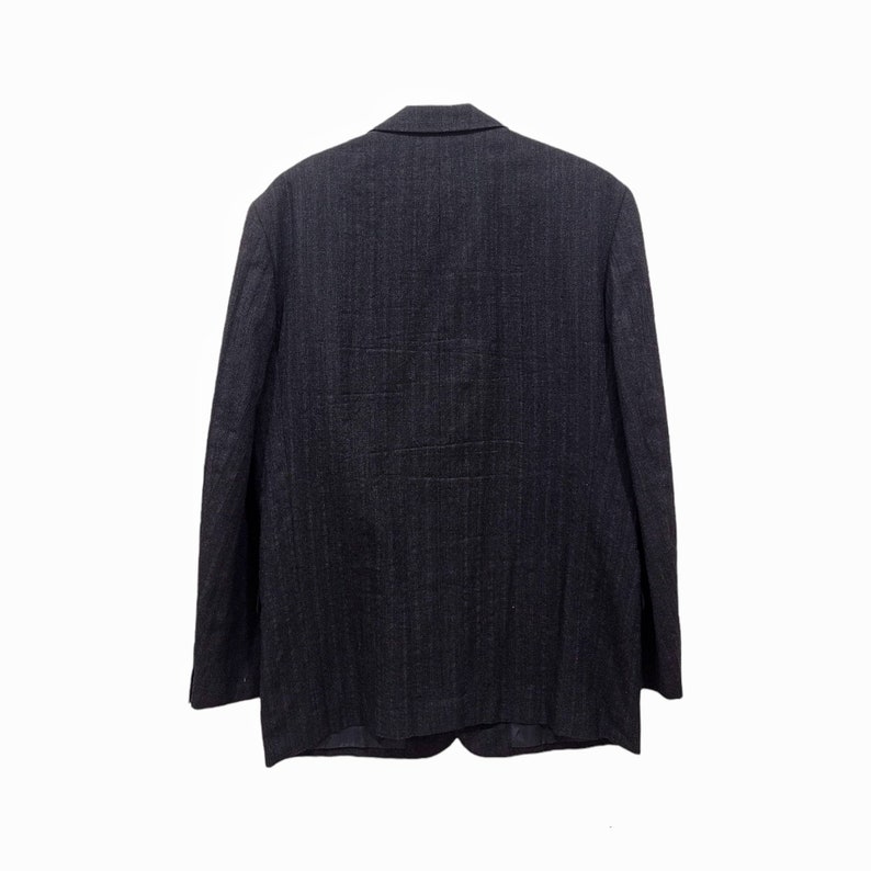 Op de afbeelding: Een donkergrijze pinstripe blazer met een reverskraag en een knoopsluiting met twee knopen.