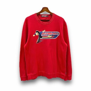 Puede incluir: Sudadera roja de manga larga con un gráfico de Astro Boy corriendo y el texto "ASTRO BOY" en un diseño de rayas amarillas, azules y rojas.