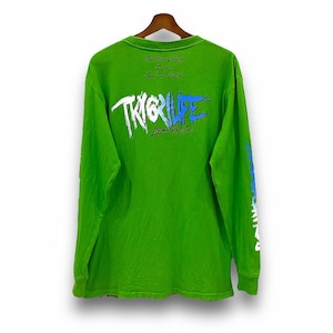 May include: Green long-sleeve t-shirt with a white and blue graphic print on the back that says "TRIGRLIFE" and "Black Real Co.". The text "Let everything fuel to love and hate" is printed above the graphic.