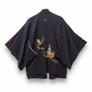 Könnte beinhalten: Schwarzer Seidenkimono mit goldener und brauner Stickerei eines Vogels und einer Flasche auf einem Zweig.