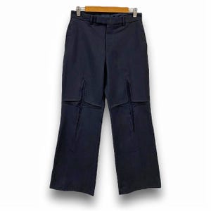 May include: Dark blue pants with a unique design featuring cutouts in the shape of stars. The pants have a straight leg and a classic fit.
