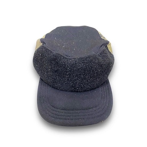 May include: A black and tan baseball cap with a velcro strap on the back. The cap has a mesh panel on the back and a solid front panel.