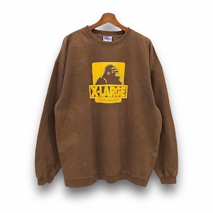Puede incluir: Sudadera marrón con un logotipo amarillo de X-Large que presenta un gorila y el texto "Clothing".