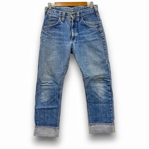 May include: Light blue denim jeans with a classic straight leg fit, cuffed at the ankles. The jeans are displayed on a wooden hanger against a white background. The denim shows signs of wear and fading.