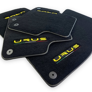 Könnte beinhalten: Schwarze Autofußmatten mit gelber "URUS"-Beschriftung und der italienischen Flagge, die darauf gestickt ist.