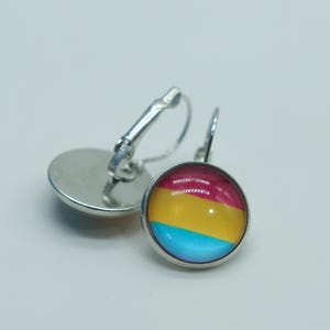 May include: A pair of silver hoop earrings with a round, colorful glass charm. The charm features three horizontal stripes in red, yellow, and blue.